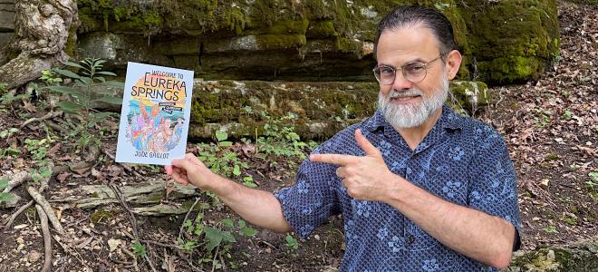 Author Jude Gaillot holding mockup of Welcome to Eureka Springs book cover